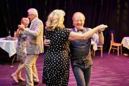 This is a photo of 4 adults dancing in 2 pairs. They are all smiling.