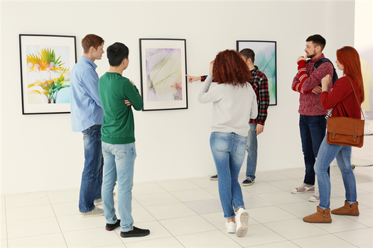 A group of young people looking at art in a gallery.
