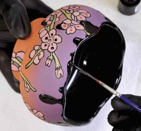 14 Apply an even coat of luster over the glossy glazed details on the fired piece.