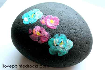 pink and blue flowers on a painted rock