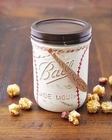 a mason jar painted to look like a baseball filled with popcorn