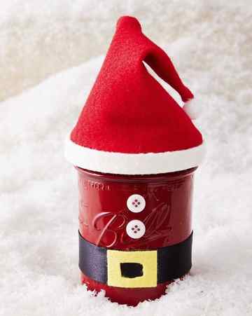 a mason jar decorated to look like santa with a felt hat and ribbon belt