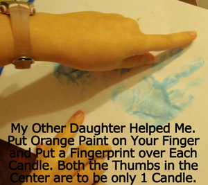 Put orange paint on your finger and put a fingerprint over each candle.