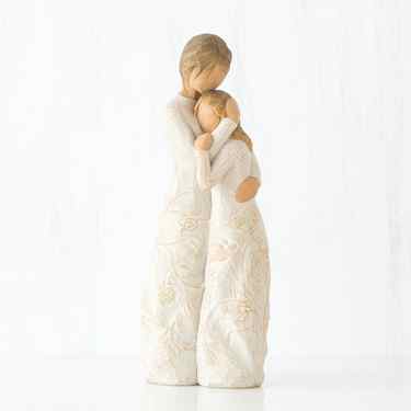 Mother faceless figurine hugging faceless daughter figurine - both standing wearing white dresses