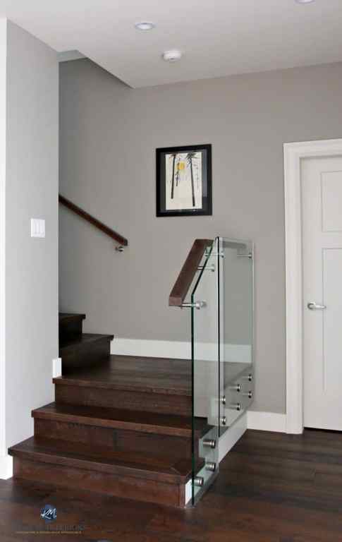 Sherwin Williams Dorian Gray in contemporary stairwell with glass and dark wood. Kylie M Interiors Decorating, Design and Online Color Consulting Services