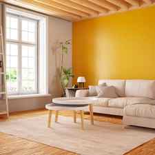interior living room with glossy orange painted wall and tan furniture