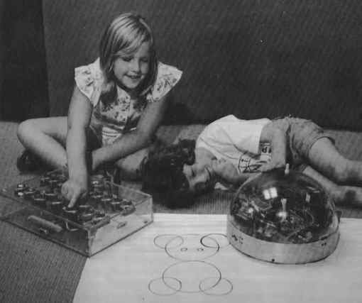 Children playing with a Logo turtle robot that can draw with a pen