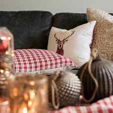 A decorative pillow with a deer and a checkered pattern