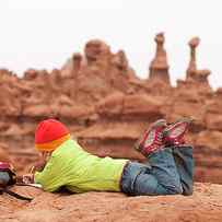 A Young Girl Drawing On A Rock While by Kennan Harvey