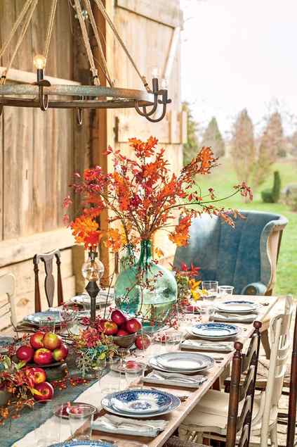 an oversized green bottle with branches with bright fall leaves and berries around is bold and cool